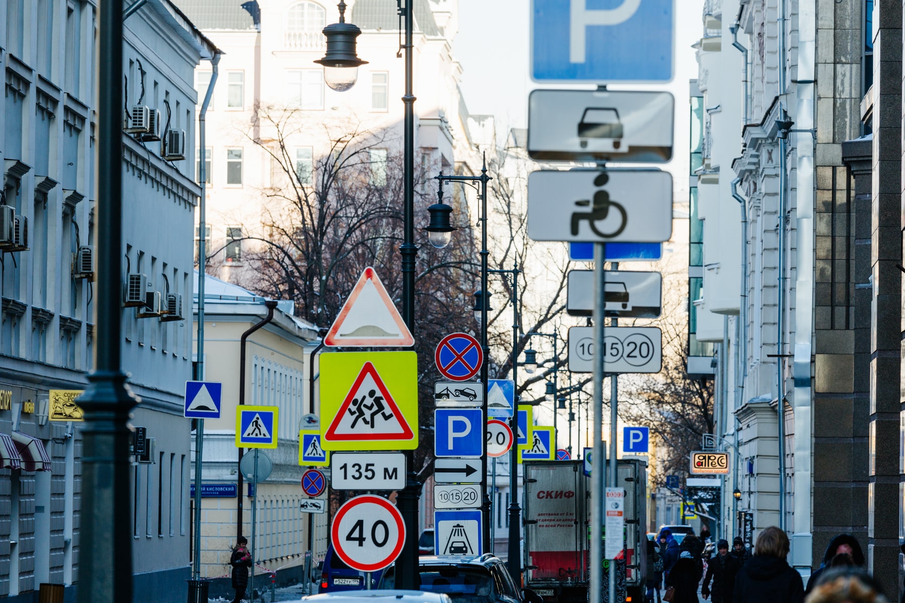 Дорожное движение в городе. Знаки на улице. Дорожные знаки на улицах города. Много знаков.